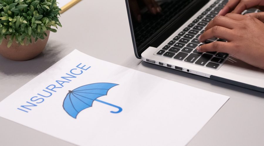 Free A Paper beside a Person Typing on a Laptop Stock Photo
